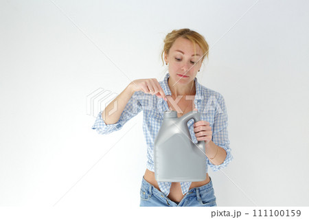 Woman holding canister of motor oil on light background Woman holding canister of motor oil on light background 111100159