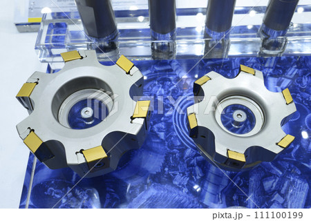 Modern double-sided inserts with long helical cutting edges, for milling, presented on stand. 111100199