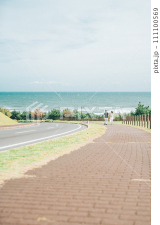 海へ続く道を歩いていくカップル 海へ続く道を歩いていくカップル 111100569