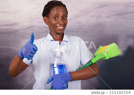 smiling young housekeeper with thumb gesture 111102159