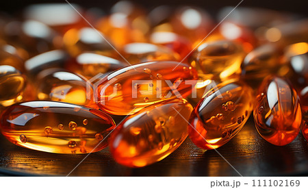 Close-up of amber Omega-3 fish oil capsules, with tiny bubbles inside, glowing on a dark wooden backdrop Close-up of amber Omega-3 fish oil capsules, with tiny bubbles inside, glowing on a dark wooden backdrop 111102169