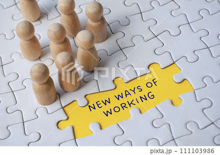 Empty jigsaw puzzle with text - new ways of working surrounded by wooden figures. Business culture 111103986