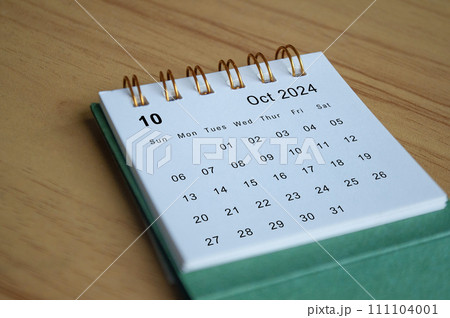 Close up side view of October 2024 calendar on wooden desk. Calendar concept Close up side view of October 2024 calendar on wooden desk. Calendar concept 111104001