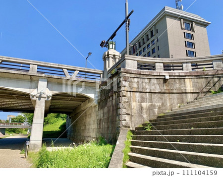 河川敷から殿橋の欄干・親柱越しに見上げる五月晴れの青空と西三河総合庁舎〈乙川河川緑地/愛知県岡崎市〉 111104159