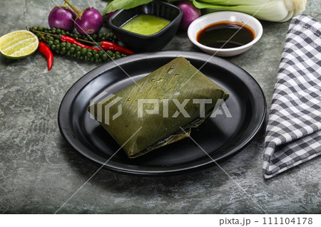 Asian cuisine - rice with filling in banana leaf Asian cuisine - rice with filling in banana leaf 111104178
