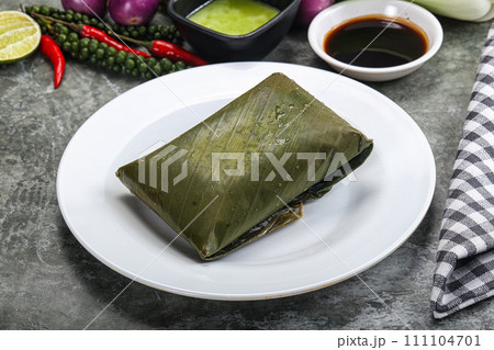 Asian cuisine - rice with filling in banana leaf Asian cuisine - rice with filling in banana leaf 111104701