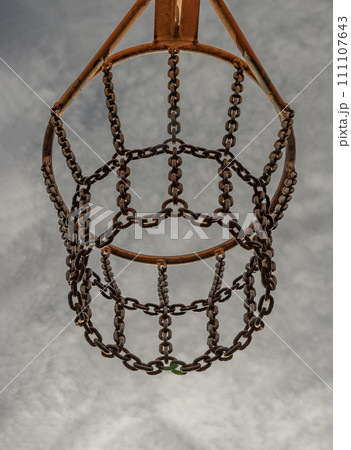 View of hoop metal and steel chain net against sky background seen from below. 111107643