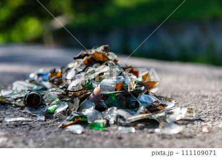 Pile of broken glass on the road. Small pieces of glass. Broken bottles on the nature. 111109071