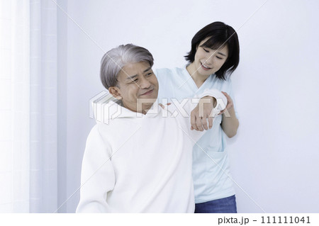 リハビリをするミドル男性と看護師の女性 111111041