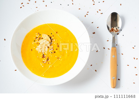 pumpkin cream soup with sesame seeds on a white background. Yellow vegetable soup with spoon 111111668