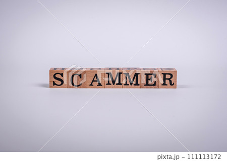 The inscription Scammer made of wooden cubes on a plain background 111113172