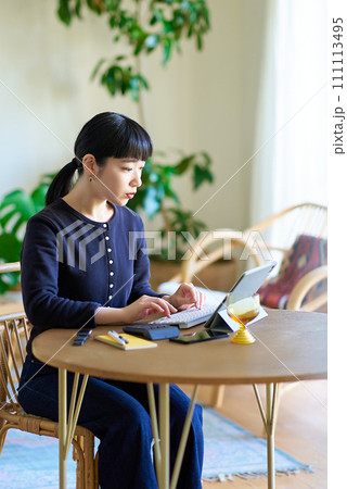カジュアルな部屋で仕事をする若い女性 カジュアルな部屋で仕事をする若い女性 111113495