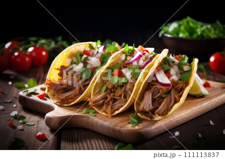 Mexican pork carnitas tacos with greens, tomato and veggies on wooden board Mexican pork carnitas tacos with greens, tomato and veggies on wooden board 111113837