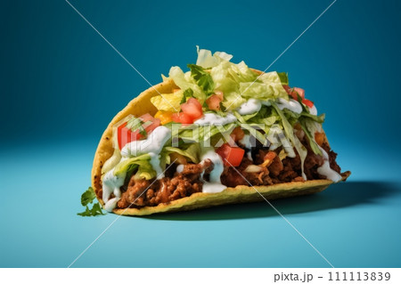 Juicy beef taco topped with sour cream and veggies on the blue background Juicy beef taco topped with sour cream and veggies on the blue background 111113839