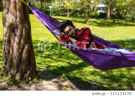 Man in a hammock feeling relaxed and rested 111114170