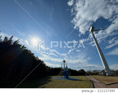 風車と風力発電・大きな海に波が打ち寄せ、青い大空と太陽と夕日が混ざり合い、高台から見下ろす実写写真 風車と風力発電・大きな海に波が打ち寄せ、青い大空と太陽と夕日が混ざり合い、高台から見下ろす実写写真 111117395