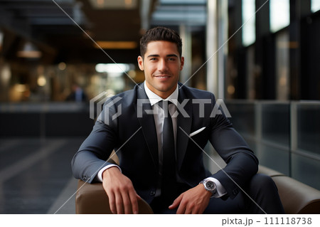 Portrait of a young business man sitting in an office lobby. 111118738