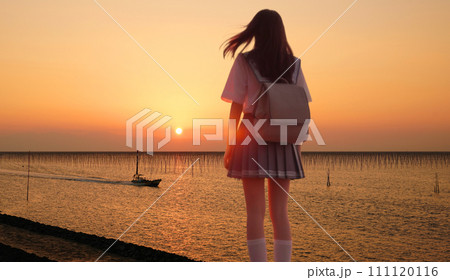 堤防に立ち沈む夕陽と港に帰る漁船を見る少女  実写とAI生成の合成  (フォーカスは夕陽と海苔棚)  堤防に立ち沈む夕陽と港に帰る漁船を見る少女  実写とAI生成の合成  (フォーカスは夕陽と海苔棚)  111120116