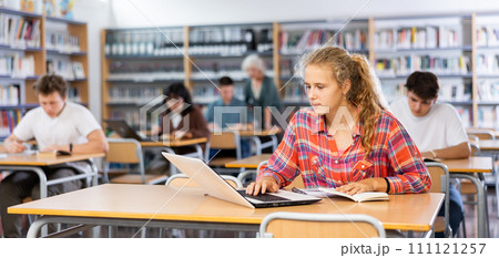 European schoolgirl, preparing for classes in the school library European schoolgirl, preparing for classes in the school library 111121257