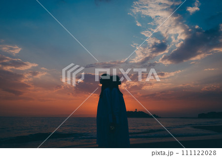 雲海に沈む夕日を眺める若い女性のシルエット 雲海に沈む夕日を眺める若い女性のシルエット 111122028