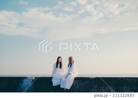 夕焼けバックに佇む若い女性 夕焼けバックに佇む若い女性 111122685