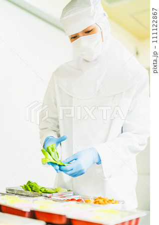 食品工場で御惣菜を詰める若い女性 食品工場で御惣菜を詰める若い女性 111122867