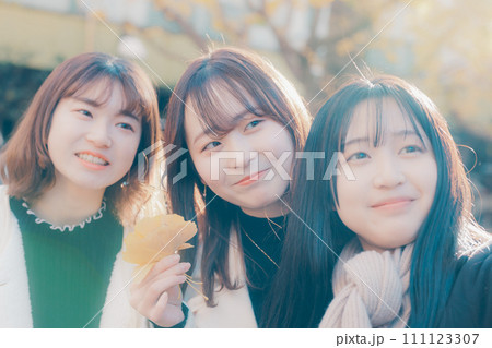 記念写真を撮る若い女性3人 111123307