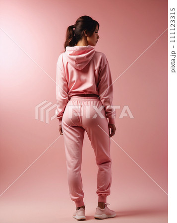 Beautiful athletic model in tracksuit on light pink background. Beautiful athletic model in tracksuit on light pink background. 111123315
