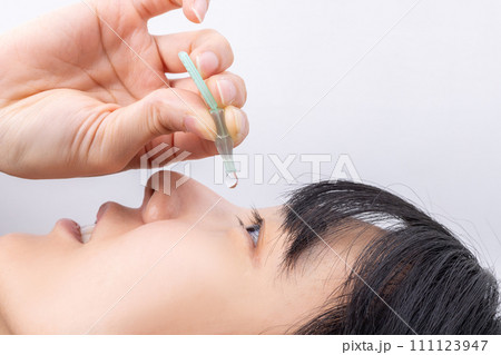 目薬をさす女性　woman applying eye drops 111123947