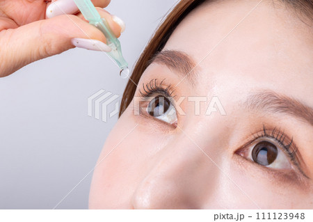 目薬をさす女性 woman applying eye drops 目薬をさす女性 woman applying eye drops 111123948
