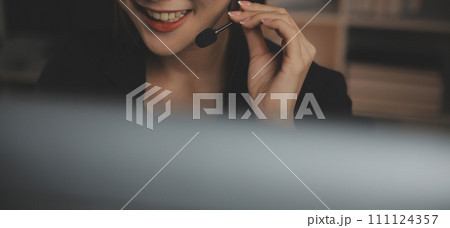 Young woman working in call centre, surrounded by colleagues 111124357