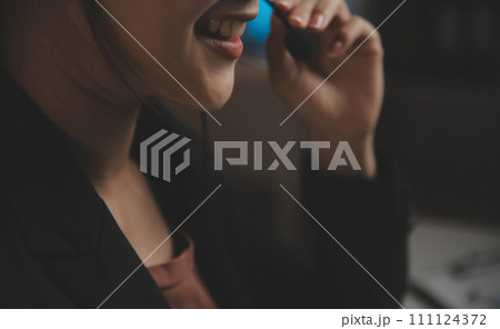 Young woman working in call centre, surrounded by colleagues 111124372