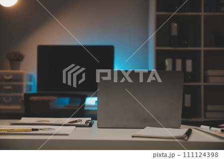 Laptop and paperwork on conference table Laptop and paperwork on conference table 111124398