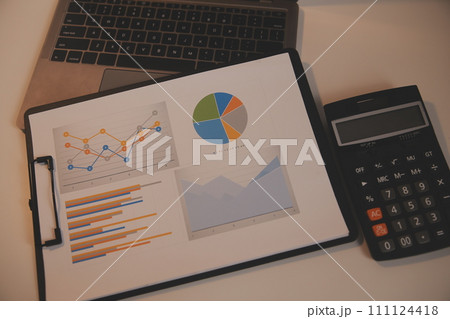 Laptop and paperwork on conference table Laptop and paperwork on conference table 111124418