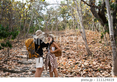 Happy LGBT Lesbian couple Travelers Hiking with Backpacks in forest Trail. LGBT Lesbian Couple Hikers with backpacks walks in mountains in vacation 111124819
