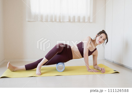 ホームローラーで脚をマッサージする若い女性 ホームローラーで脚をマッサージする若い女性 111126588