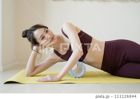 ホームローラーで体側をほぐす若い女性 111126844