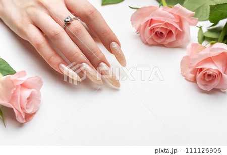 Female Hands on a white background with beautiful pearl manicure.Hands on a brown background and beautiful pearl manicure Female Hands on a white background with beautiful pearl manicure.Hands on a brown background and beautiful pearl manicure 111126906