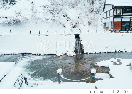 Foot bath hot spring in Ginzan Onsen with snow fall in winter season is most famous Japanese Hot Spring in Yamagata, Japan. Foot bath hot spring in Ginzan Onsen with snow fall in winter season is most famous Japanese Hot Spring in Yamagata, Japan. 111129158