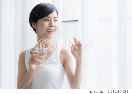 ビューティーイメージ 窓辺に立ち水を飲む女性 ビューティーイメージ 窓辺に立ち水を飲む女性 111130421
