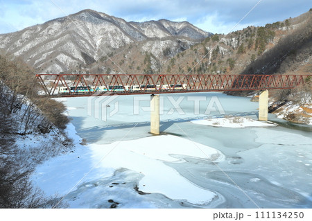 野岩鉄道「湯西川橋梁と凍り付いた五十里湖」冬山背景に 111134250