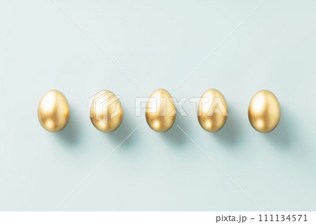 a row of golden eggs on a blue background top view flat lay a row of golden eggs on a blue background top view flat lay 111134571
