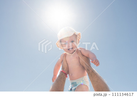 Father and child in a playful sky-high embrace under the sun. Concept of happiness and fatherly affection 111134617