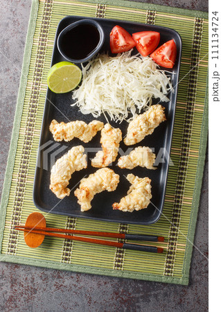 Oita Style Chicken Tempura Toriten with dipping sauce and cabbage salad closeup on the plate. Vertical top view 111134724