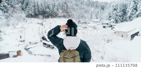 Woman tourist Visiting Ginzan Onsen in Yamagata, happy Traveler sightseeing Japanese Onsen village with Snow in winter season. landmark and popular for attraction in Japan. Travel and Vacation concept 111135708