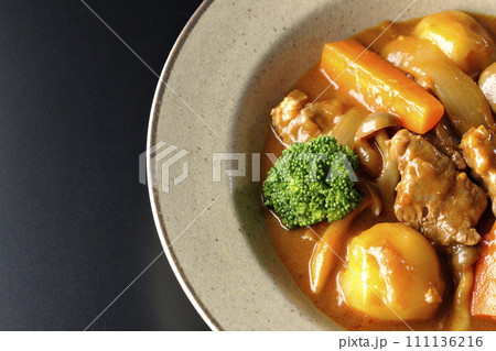 ブロッコリーや人参、しめじなど沢山の具材が入っているビーフシチューを黒背景で俯瞰撮影 111136216