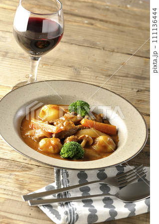 ブロッコリーや人参、しめじなど沢山の具材が入っているビーフシチューと赤ワイン 111136444