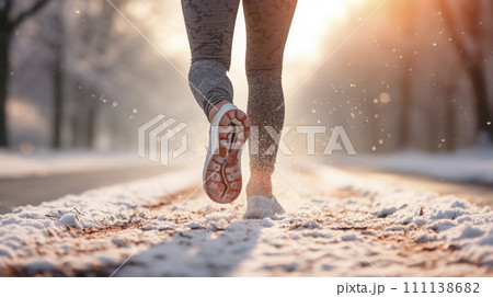 Back view of woman legs with sport shoes jogging in snow. Sporty legs in sneakers in the snow. Back view of woman legs with sport shoes jogging in snow. Sporty legs in sneakers in the snow. 111138682