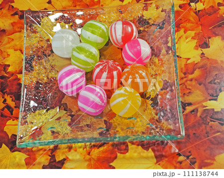 ガラス皿に並べた懐かしくておいしい色とりどりの飴玉 111138744