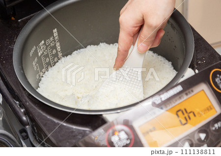 炊きあがったごはんをしゃもじでまぜる 111138811